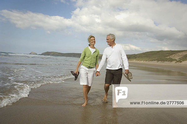 Couple walking hand in hand on a beach