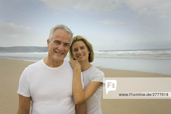 Porträt eines am Strand lächelnden Paares