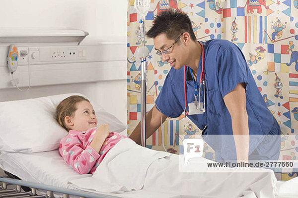 Ein männlicher Arzt besucht ein kleines Mädchen.