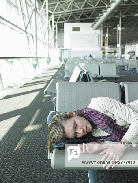 schlafende Frau auf der Bank im Flughafen