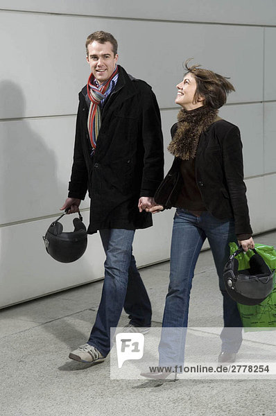 Couple walking with motorcycle helmets