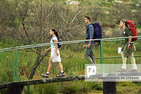 Hikers walking across footbridge