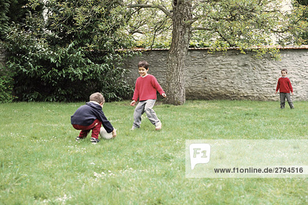 Jungen spielen mit Ball im Hof