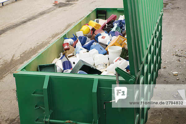 Großer Abfalleimer voll mit weggeworfenen Kunststoffbehältern