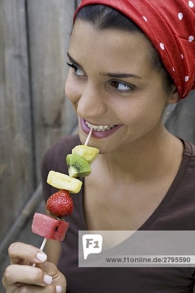 Junge Frau mit Früchtespiess