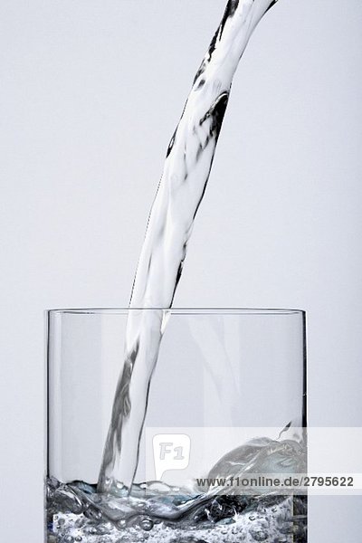 Wasser in Glas eingiessen