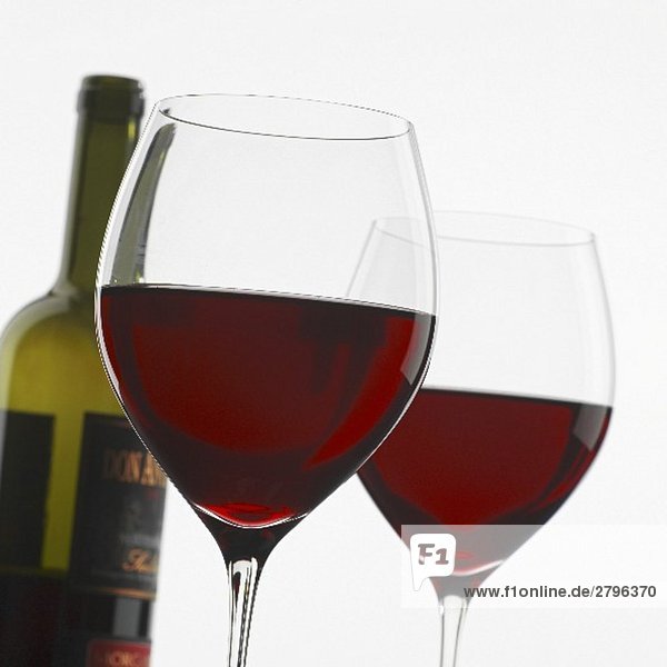 Zwei Rotweingläser vor Rotweinflasche