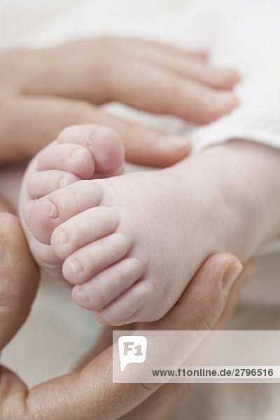 Hände halten Babyfüsse