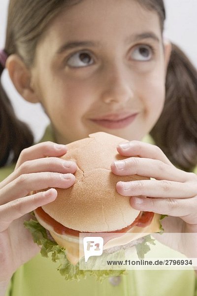 Kleines Mädchen hält Cheeseburger