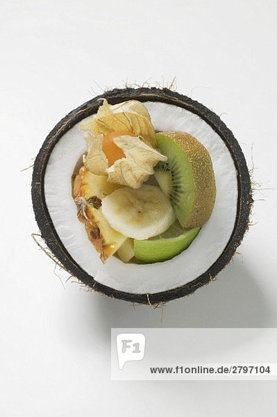 Frische exotische Früchte in einer halben Kokosnuss