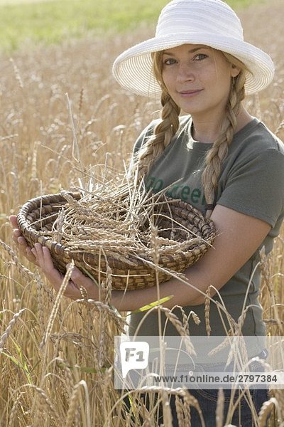 Frau mit Korb in einem Getreidefeld