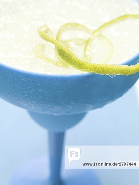 Frozen Margarita mit Limettenzesten im blauen Glas