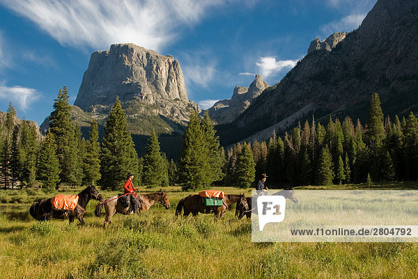 People riding horses with mountain in background  Wind River Range  Wyoming  USA