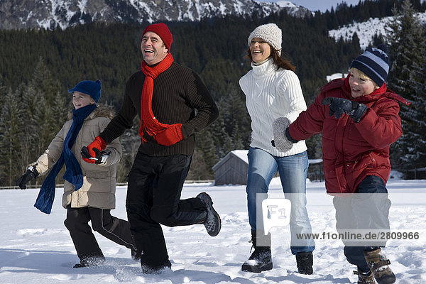 Family enjoying in snow covering landscape