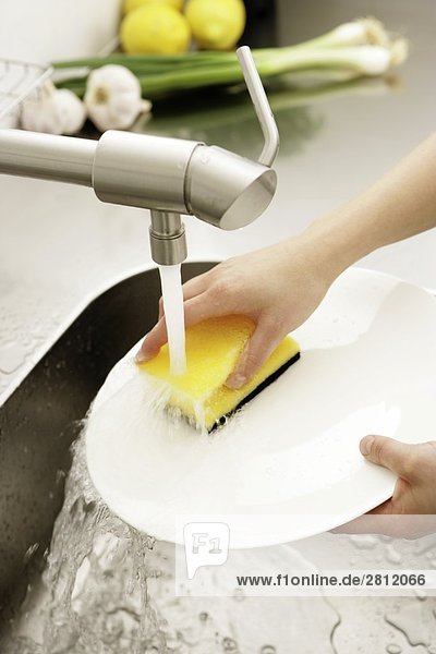 Person waschen Platte in Küche