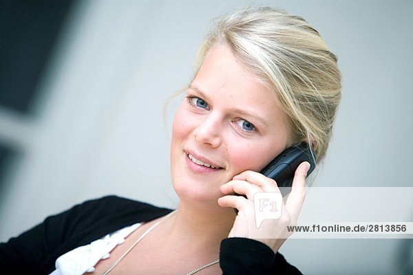 Portrait einer blonden Frau mit einem Mobiltelefon Schweden.
