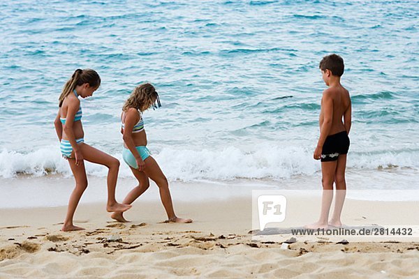 Three children on a beach Thailand.