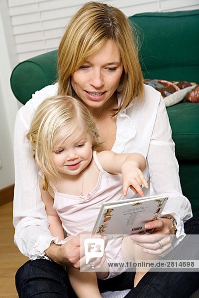 A girl reading a book with her mother Sweden.