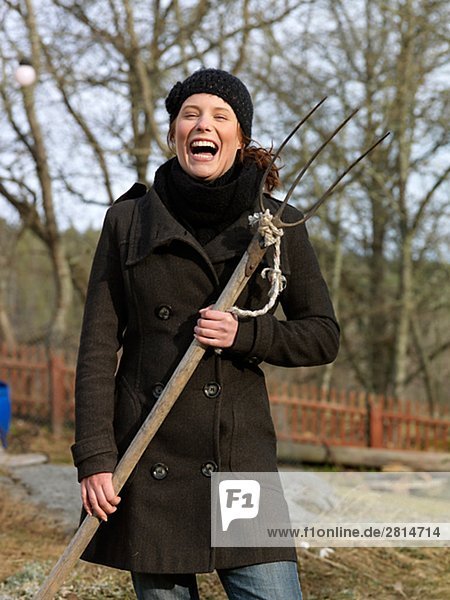 A young woman holding a manure-fork Sweden.
