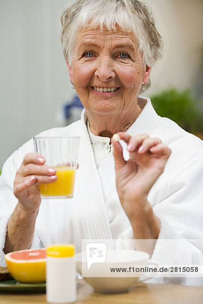 An elderly woman taking her medicine Sweden.
