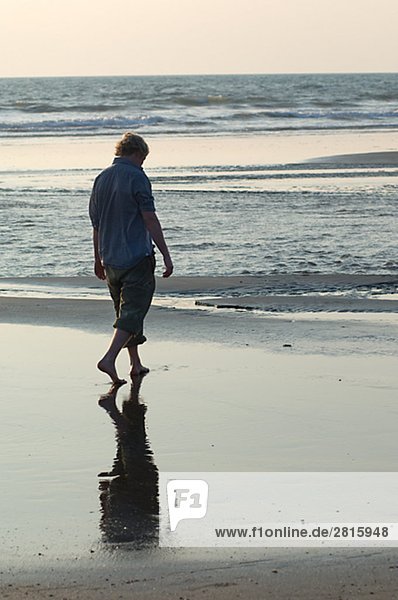 Ein Mann zu Fuß am Meer Goa Indien.