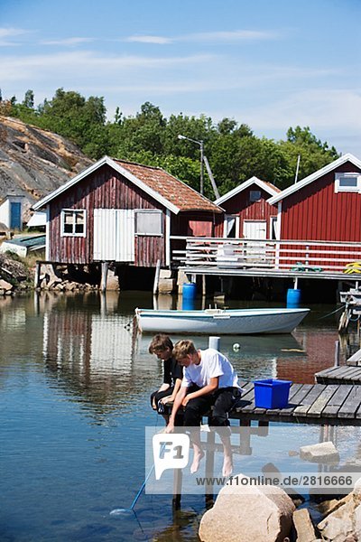 Two boys fishing Smogen Bohuslan Sweden.