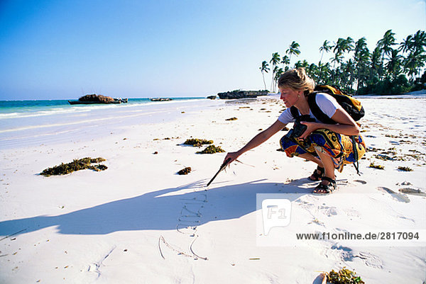 Eine Frau an einem Strand Zanzibar.