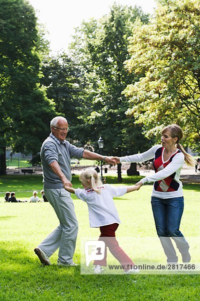 Woman senior man and girl playing in the park Sweden.
