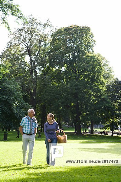 Woman and senior man walking in the park Sweden.