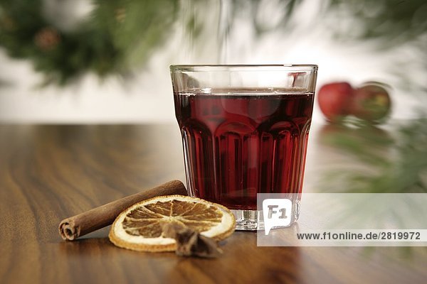 Glass of mulled wine with cinnamon stick and slice of orange