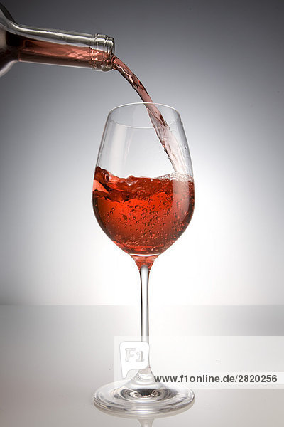 Eingiessen von Rotwein in ein Glas  close-up