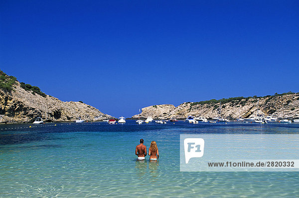 Rückansicht des Paar steht in seichtem Wasser  Cala Moli  Ibiza  Balearen Inseln  Spanien