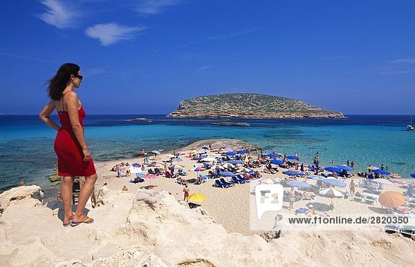 Frau blickt auf Menschen am Strand Cala Comte  Ibiza  Balearen Inseln  Spanien