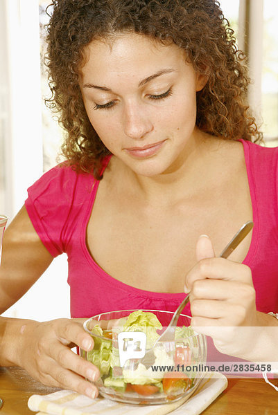 Frau isst ein Endivie und Tomaten-Salat