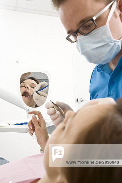 Männlich Zahnarzt Untersuchung des Patienten Zähne