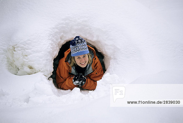 Eine Frau crawlt von einer 'Quinze' Schnee Hütte im Algonquin Provincial Park  Ontario  Kanada.