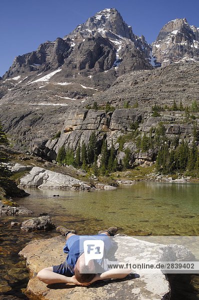 Hiker relaxing on a rock  Lake O'Hara  Yoho National Park  British Columbia  Canada.