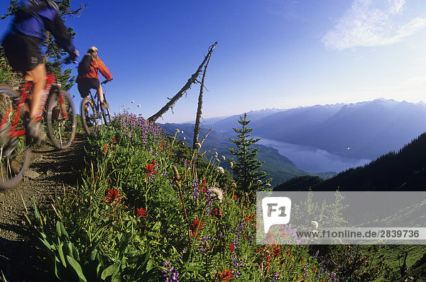 Zwei Frau Mountain-Biker am Idaho Peak mit Valhallas hinter  Slocan Tal  Kootenays  British Columbia  Kanada.