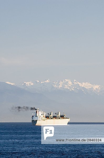 A Freighter passing through the Strait of Juan de Fuca with Washington's Olympic Mountains in the background  British Columbia  Canada.