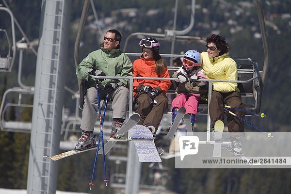 A young family on a chairlift  Whistler Mountain  British Columbia  Canada.