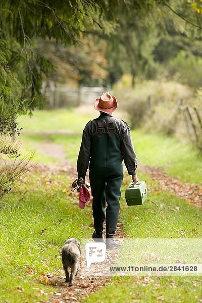 Mensch und Hund zu Fuß home nach einem Angeltag. Courtenay  Vancouver Island  British Columbia  Kanada