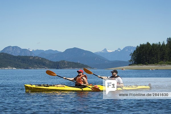Kayakers ply the waters of Rebecca Spit Marine Provincial Park on Quadra Island  off the east coast of Vancouver Island  British Columbia  Canada.