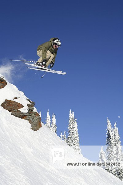 Männliche Skifahrer springen Felsbrocken am Silver Star Mountain Resort  Vernon  British Columbia  Kanada.