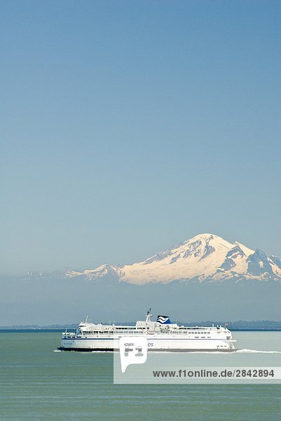 A BC Ferry crosses the Strait of Georgia with Mount Baker in background on it's way to Vancouver  British Columbia  Canada.