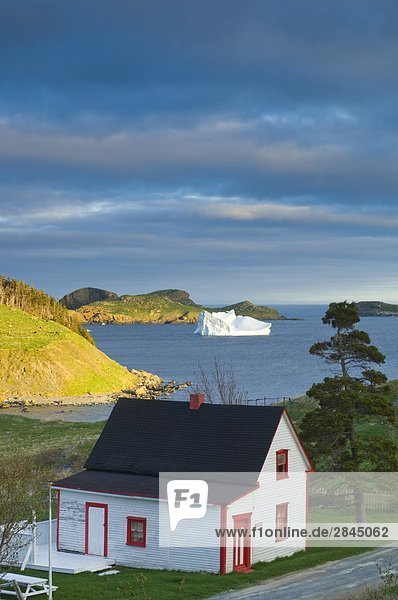 Coastal home and iceberg  Newfoundland  Canada