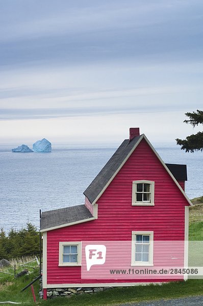 Coastal home and iceberg  Newfoundland  Canada