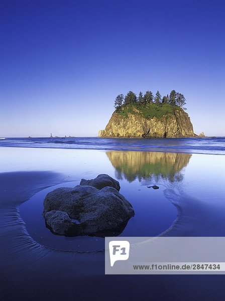 USA Washington State Olympic National Park rock in sand on Shi Shi Beach with sea stacks