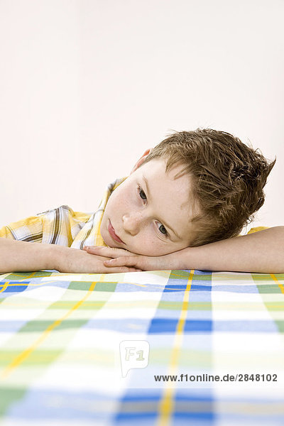 Boy leaning on table and thinking