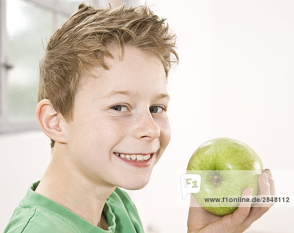 Boy having granny smith apple and smiling