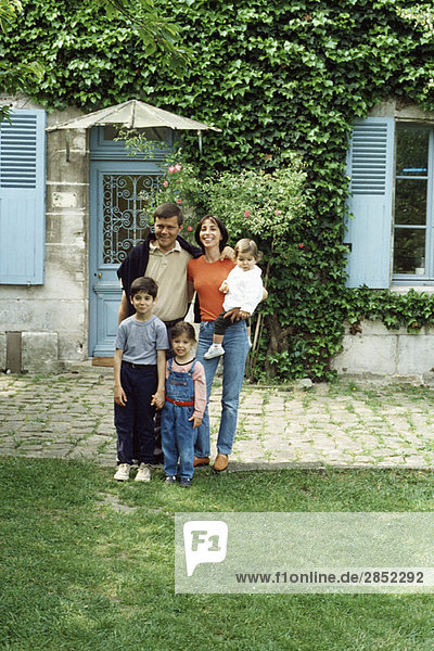 Familie steht vor dem Haus  Porträt